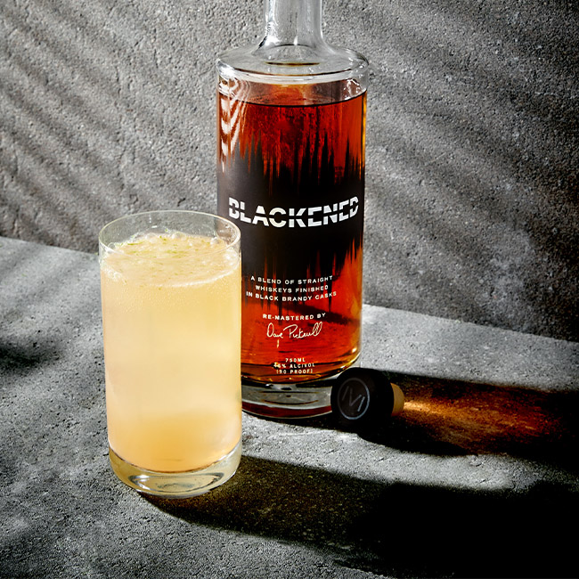 Presbyterian Whiskey Cocktail in a Glass in front of a bottle of BLACKENED American Whiskey