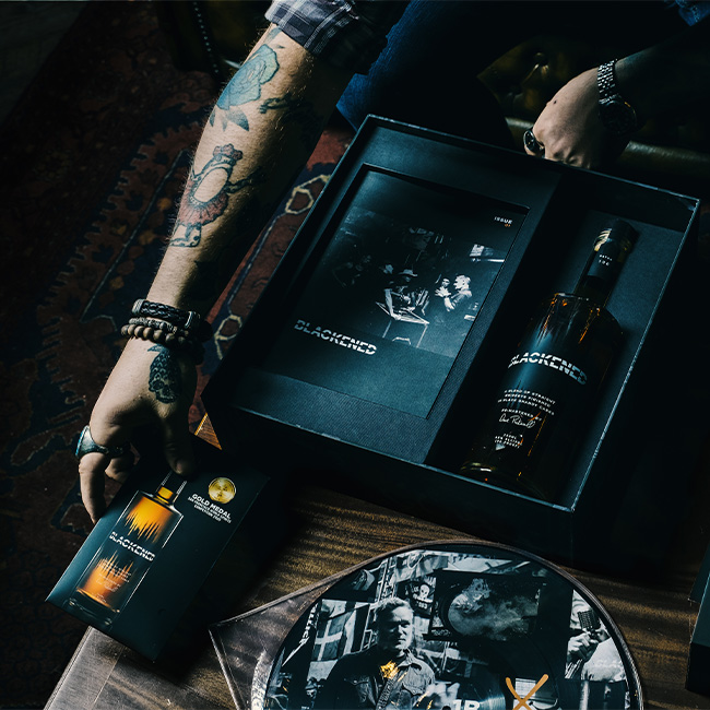 Someone unboxing the BLACKENED American Whiskey Batch 100 Box